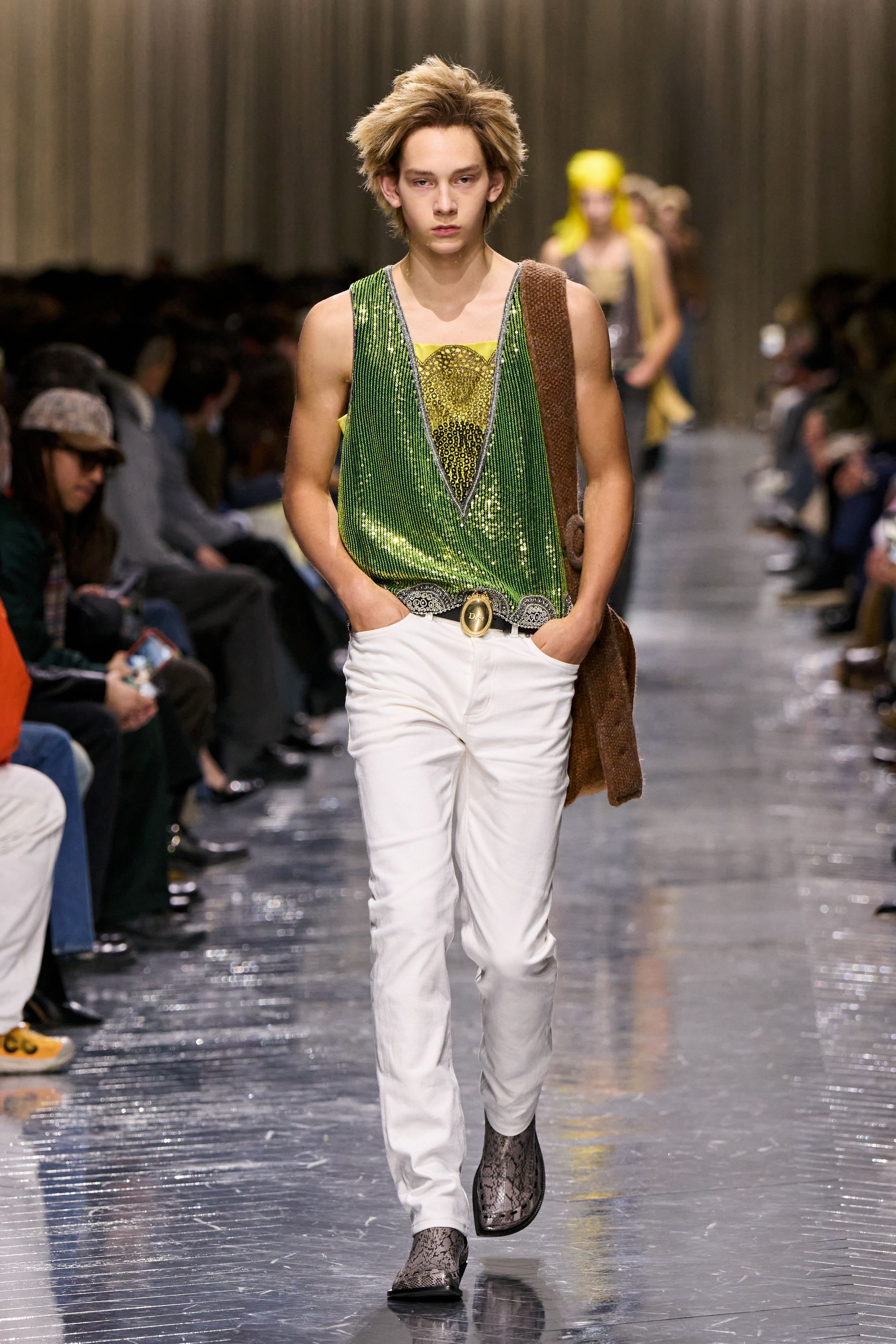 本季 Dior Men 2026 秋冬在克制与叛逆之间建立起新的男性气质坐标。轮廓上，柔软针织、披风式外套与军装结构形成张力对照，模糊正装与休闲、性别与功能的边界；材质层面，羊毛、皮革、毛绒与轻量技术面料并置，强化“触感叙事”。色彩从学院派的灰蓝、橄榄绿过渡至点状印花与手工肌理，传递一种被精心编排的随性。整体呈现出一种“新贵游牧者”形象：既有高级定制的工艺根基，又拥抱当代青年对自由、混搭与身份流动性的渴望-顽石频道趋势研究